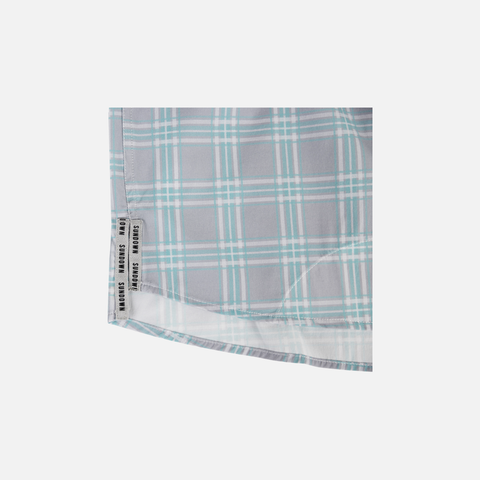 Closeup of bottom side edge of Seafoam/Grey Plaid Pearl Snap Field Shirt L/S showing grey side slits with black "SUNDOWN" text - Sundown Supply Co