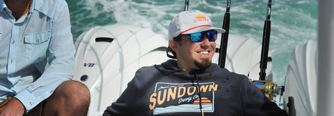 Man on boat wearing Sundown Greetings Heavyweight Navy hoodie