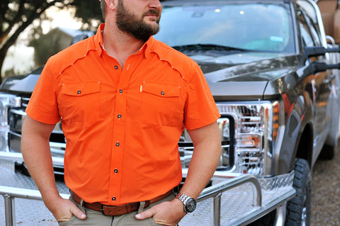 Man wearing blaze s/s performance field shirt in front of truck