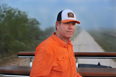 Orange/Navy/White Sundown Supply Meshback Snapback on man wearing orange long sleeve field shirt