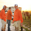 Man on ranch wearing Orange/Navy/White Sundown Supply Meshback Snapback