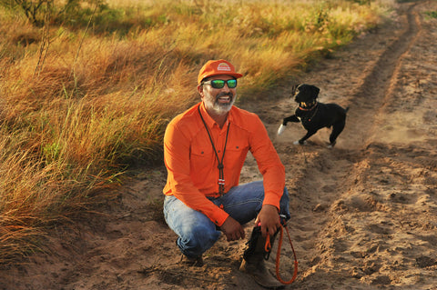 man with dog wearing Long sleeve blaze performance field shirt and blaze sundown hat