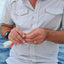 Person holding a fishing lure with water in the background