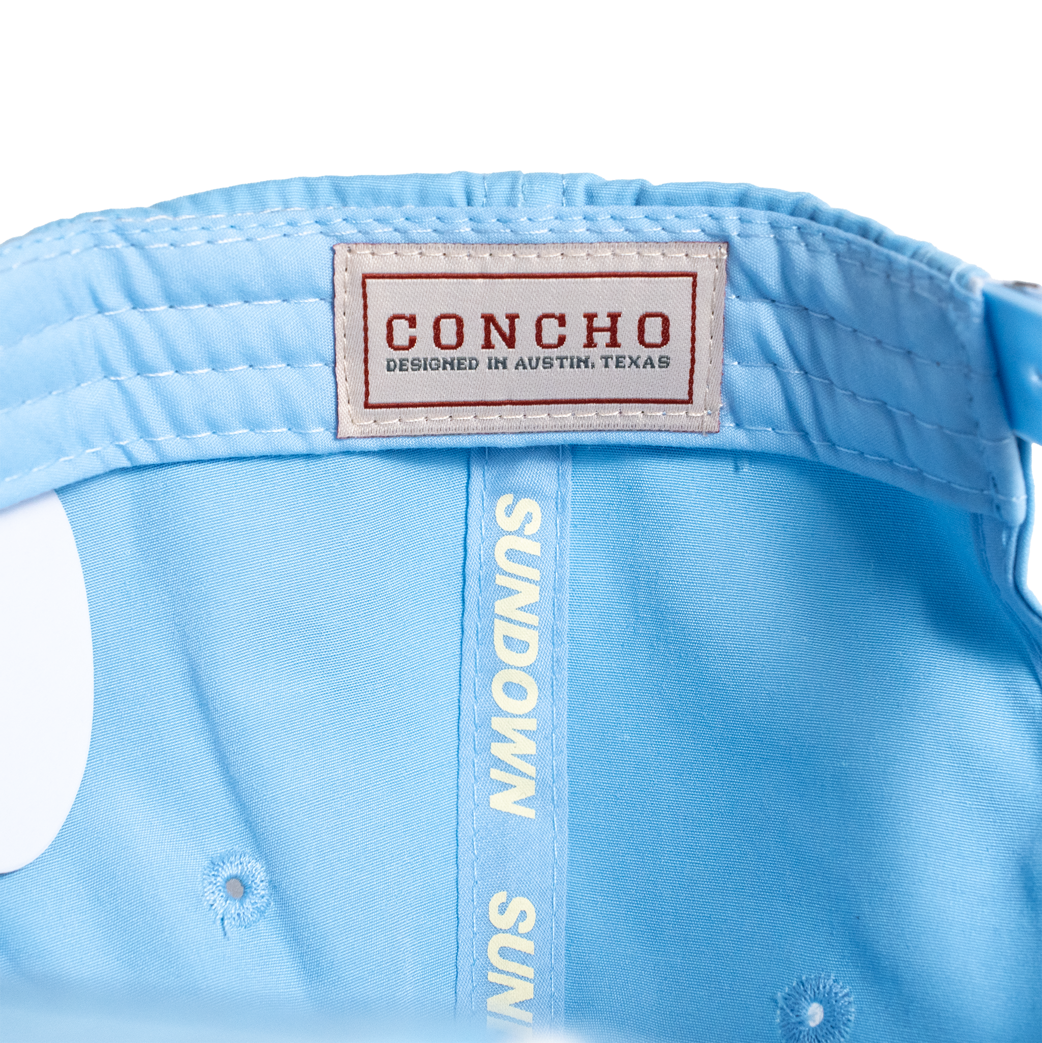 Light blue cap with 'Concho' label and 'Sundown Sun' text on a white background
