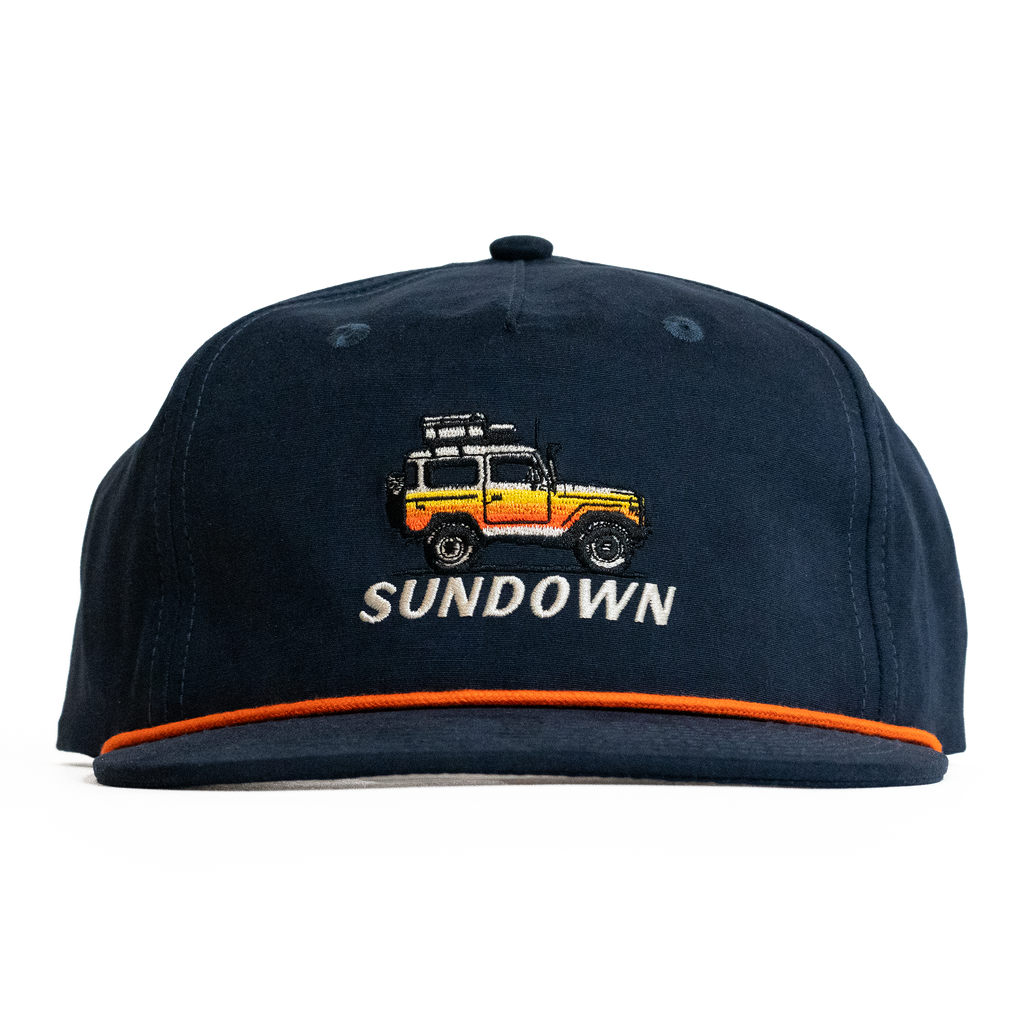 Navy blue cap with embroidered design and 'Sundown' text on a white background