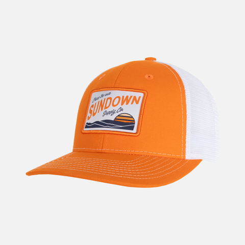 Orange/White Postcard Meshback Snapback with postcard patch on front with text "Chase the sun SUNDOWN Supply co"