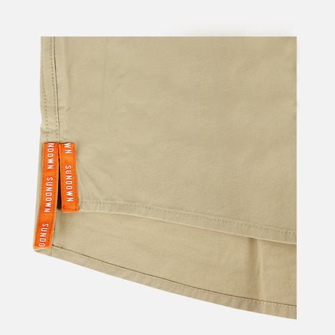 closeup of side vents on bottom side of s/s Khaki performance field shirt with white embroidered "SUNDOWN" text