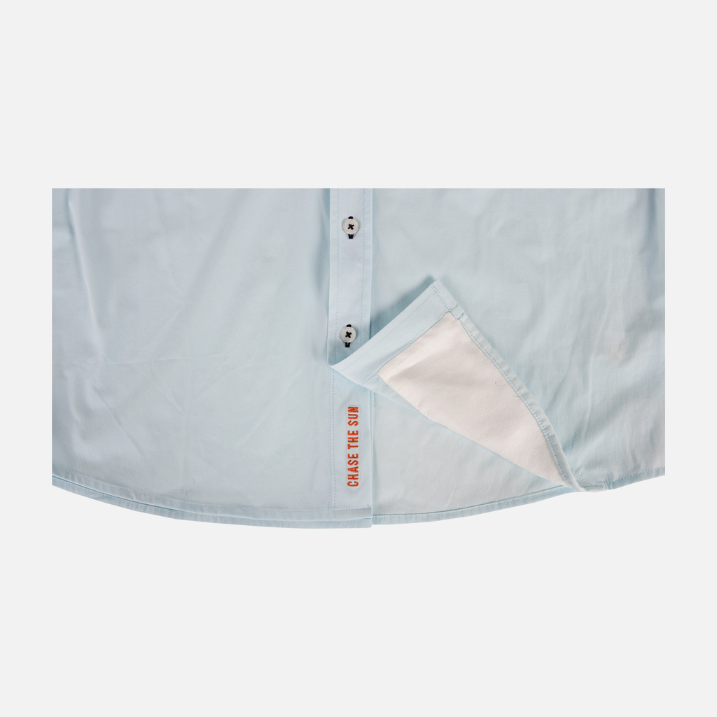 bottom of Long sleeve faded sky performance field shirt showing "CHASE THE SUN" text inside where buttons meet