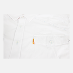 closeup of chest of white performance field shirt short sleeve showing front pocket with orange sundown label